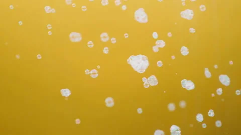 White soap bubbles flutter on a yellow background in slow motion Stockbeeldmateriaal 137704129