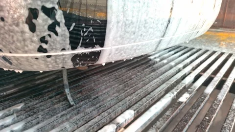 White soap sud of detergent dripping down from black car during car wash process Stock Footage 257699839