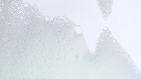 White soap suds flowing down window glass. Cleaning windows with cleaning d.. Stock Footage 269323390
