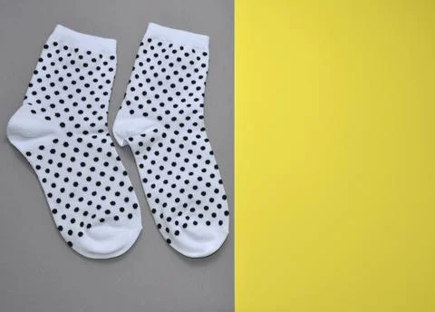 White socks on a gray-yellow background. Stock Photos
