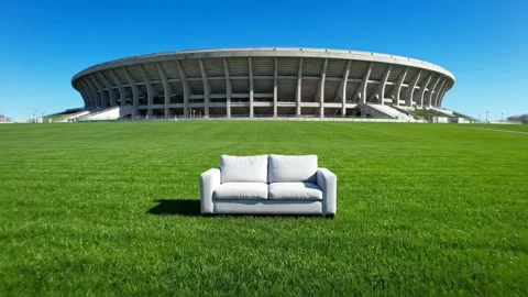 White Sofa on Green Grass Field with Stadium in Background. Stock Footage 321468072