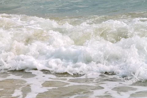 White soft wave rolling splash on empty tropical sandy beach in sunny day Stock Photos