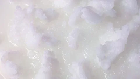 White solid coconut oil pieces circle rotation close up top view Stock Footage 257126094