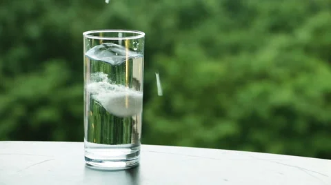 White soluble tablet (meltlets) dissolving in a water glass Vídeo Stock 65048954