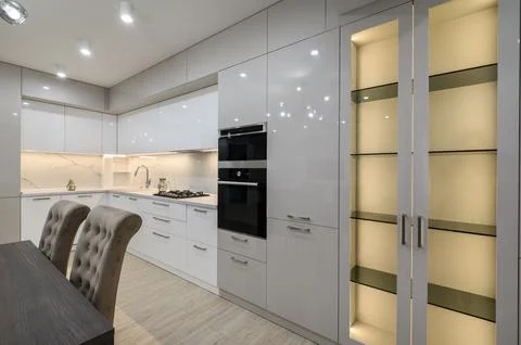 White spacious kitchen interior with dining room table and chairs Stock Photos