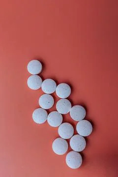 White speckled tablets arranged in an arrow shape against. Stock Photos