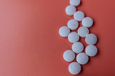 White speckled tablets arranged in an arrow shape against. Stock Photos