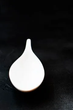 White spoon on black background. Stock Photos