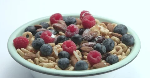 White spoon mixing a corn rings with berries and milk Stock Footage 76996514
