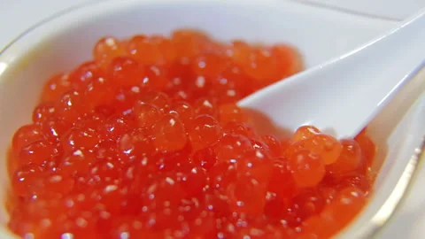 White spoon scoops red caviar from caviar Stock Footage 103105252