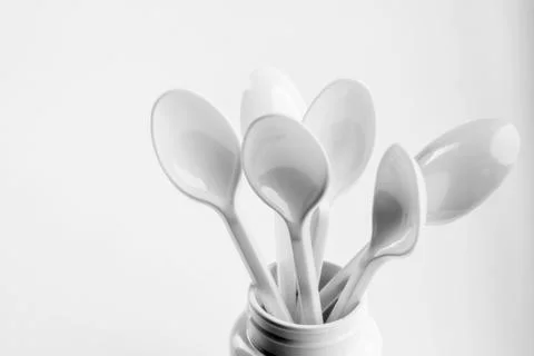 White Spoons in a Container on White Background Foto stock