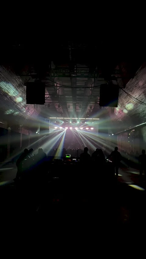 White spotlight in dark room. Unrecognizable black silhouettes of people Stock Footage 293939818