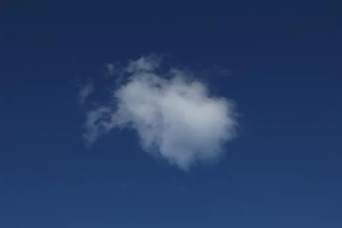 White, spring cloud in the blue sky. Stock Photos