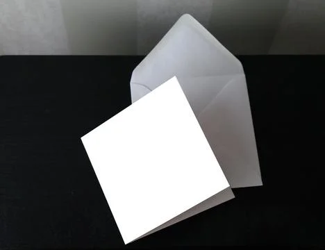 White square postcard and envelope on black table, copy space, selective focus Stock Photos