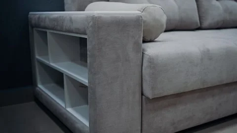 White, square shelves inserted at the edge of a comfortable beige sofa. Beige Stock Footage 235059152