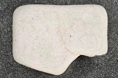 White square stone on black sand on the beach Stock Photos