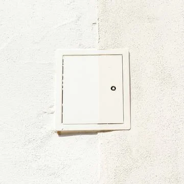 White square utility access hatch on textured wall Stock Photos
