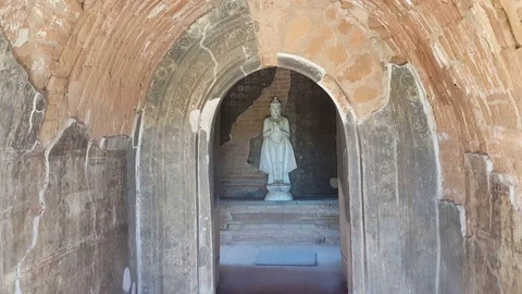 White standing Buddha statue inside ancient temple, arched passage, Bagan Vídeos de archivo 78886277