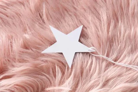 White star shape on soft pink furry background Stock Photos