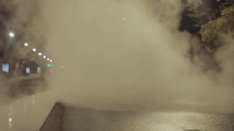 White steam cloud from underground communication system covering night city road Stock Footage 73022777