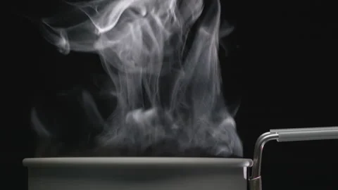 White Steam rises from a grey pot that is behind the scenes. Stock Footage 144359874