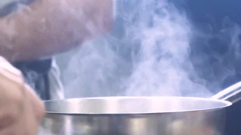 White Steam Rises from the hot Pan. Cooking in the pan in the kitchen Video stock 150590558