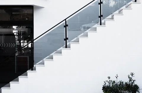 White steps with glass railing. Stone staircase in residential house, buildin Foto stock