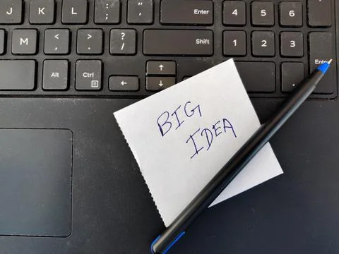 A White sticky note with text BIG IDEA and pen on top of laptop keyboard Stock Photos