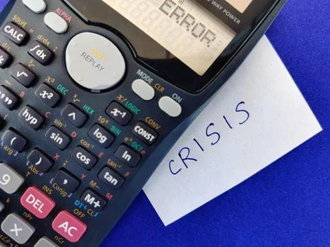 A White sticky note with text CRISIS kept under scientific calculator showing Stock Photos