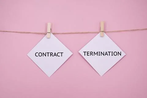 White sticky note with the word CONTRACT TERMINATION on PINK background Stock Photos