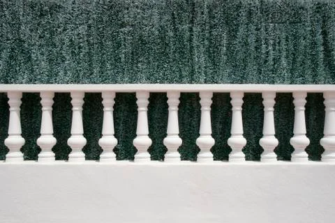 A white stone balustrade in front of an artificial green hedge, menorca, bale 写真素材