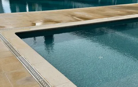 White stone edge of pool and blue pool water texture. Top view, copy space,.. Stock Photos