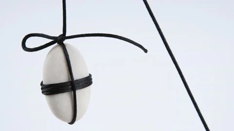 White Stone Hanging Using Black Rope. Stock Footage 55676192