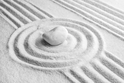 White stone on sand with pattern. Zen, meditation, harmony Stock Photos