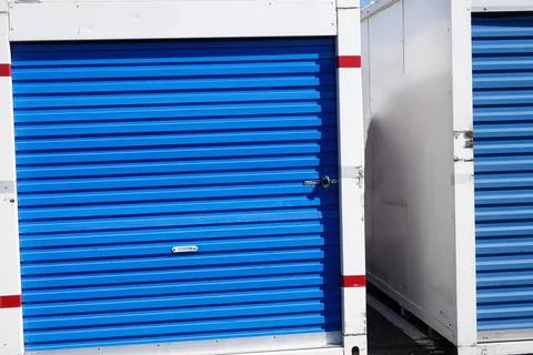 A white storage pod container with a blue door on a asphalt road Stock Photos
