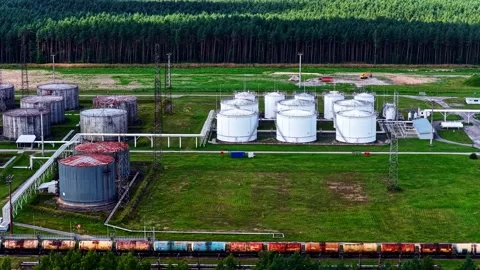 White Storage Tanks and Freight Train at Forest Industrial Facility Stock-Footage 333326006