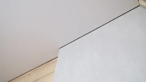 White stretch ceiling in the living room. Ceiling and wall joint. Floating ceili Stock Footage 244686422