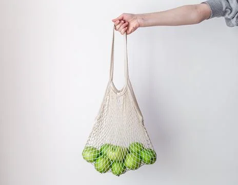 White string bag with green apples on a white background. Stock Photos