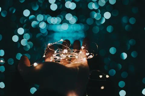 White string lights in palm of hand Stock Photos