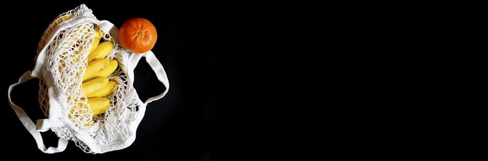 White string mesh bag filled with fruit isolated on a black background. space Foto stock