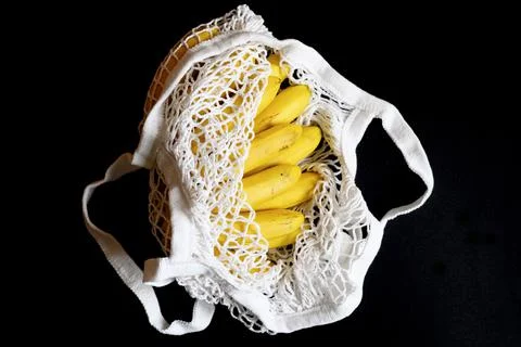White string mesh bag filled with fruit isolated on a black background Foto stock