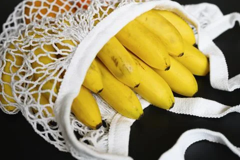 White string mesh bag filled with fruit isolated on a black background Foto stock