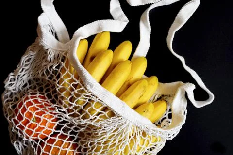 White string mesh bag filled with fruit isolated on a black background Foto stock
