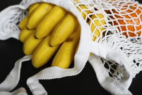 White string mesh bag filled with fruit isolated on a black background Foto stock