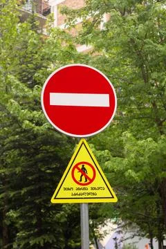 White stripe on red circle. No entry. Yellow triangle with icon of walking man Stock Photos