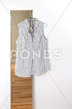 White striped blouse hanging on a mirror Stock Photos
