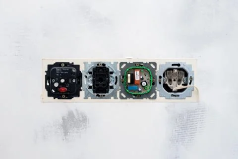 White stucco wall texture this open electrical outlets and switches Stock Photos