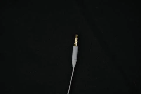 White studio headphone cable and jack for recording podcast on black backgrou Stock Photos
