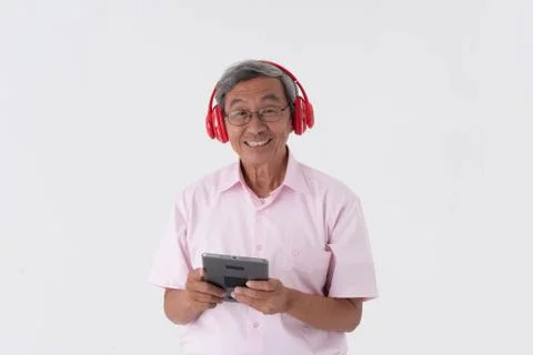 White studio portrait of senior asia retired elderly man wear red headphone l Stock Photos
