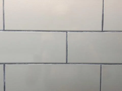 White subway tile wall with grout lines in minimalist bathroom or kitchen Stock Photos